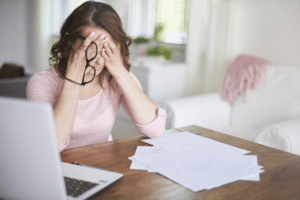 Stressed business woman holding her head in her hands.